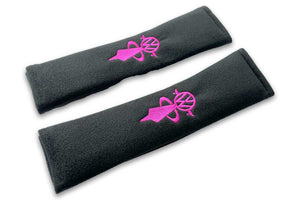 VW Bobblehead logo embroidered seat belt covers shown in black with pink woman embroidery