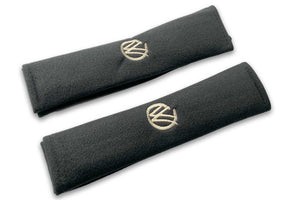 VW Graffiti logo embroidered seat belt covers shown in black with cream embroidery