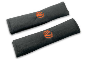 VW Graffiti logo embroidered seat belt covers shown in black with orange embroidery