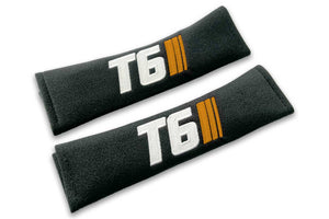T6 Stripes logo embroidered on padded seat belt covers shown in black with white and orange embroidery.