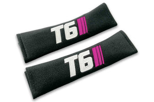 T6 Stripes logo embroidered on padded seat belt covers shown in black with white and pink embroidery.