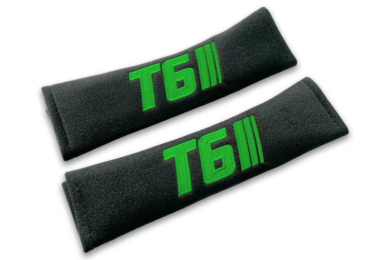 T6 Stripes single colour logo embroidered on padded seat belt covers shown in black with blue embroidery.