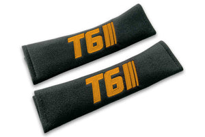 T6 Stripes single colour logo embroidered on padded seat belt covers shown in black with orange embroidery.