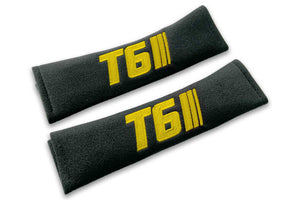 T6 Stripes single colour logo embroidered on padded seat belt covers shown in black with yellow embroidery.