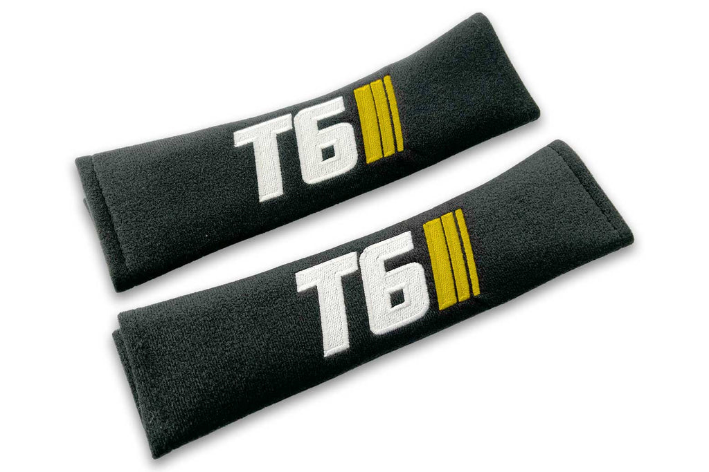 T6 Stripes logo embroidered on padded seat belt covers shown in black with white and yellow embroidery.