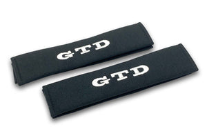 GTD embroidered seat belt covers shown in black with blue and white embroidery