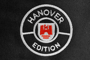 Hanover Edition logo show in white with red accent embroidered into black carpet