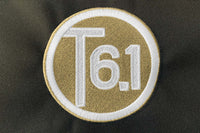 T6 point 1 embroidered circle logo with white text over a cream background