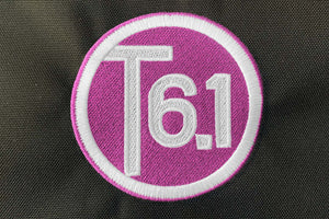 T6 point 1 embroidered circle logo with white text over a pink background