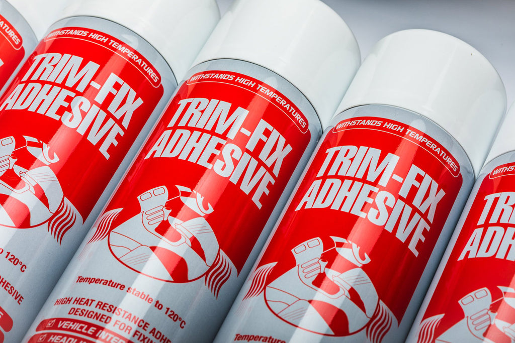 cans of Trim Fix spray adhesive, red can with white writing